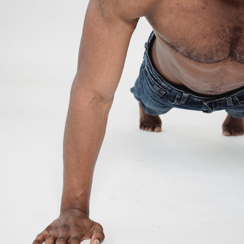 Close-up shot of a man's focused expression during a challenging bodyweight exercise.
