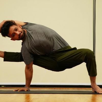 Man holding a difficult balance pose on one leg.