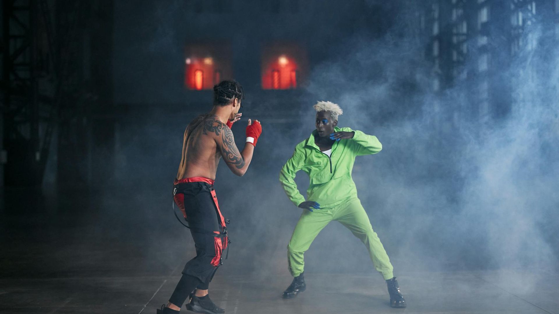 Man in a focused athletic stance in a spacious, light-filled room.